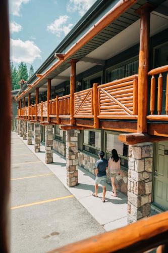 two people are sitting outside of a building at Mountaineer Lodge in Lake Louise