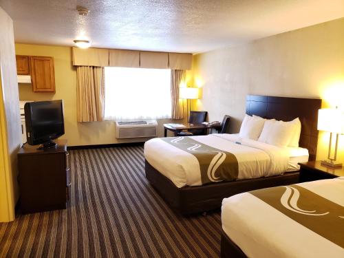 Habitación de hotel con 2 camas y TV de pantalla plana. en Quality Inn & Suites, en Vancouver