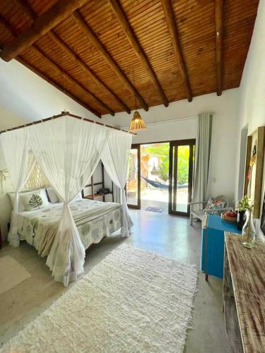 a bedroom with a bed with a mosquito net at VILA TRANCOSEAR in Trancoso