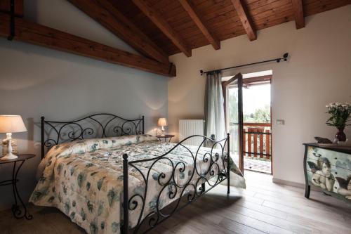a bedroom with a bed and a balcony at Dai Minisins in Savorgnano
