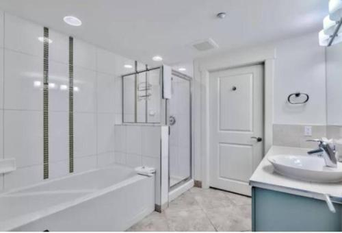 y baño con bañera, lavamanos y ducha. en 3 bedroom Sandestin condo in Baytowne Wharf!, en Destin