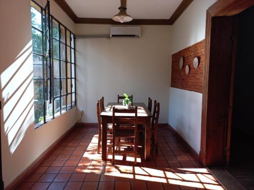 a dining room with a table and some windows at Casa Araucaria in Concepción del Uruguay