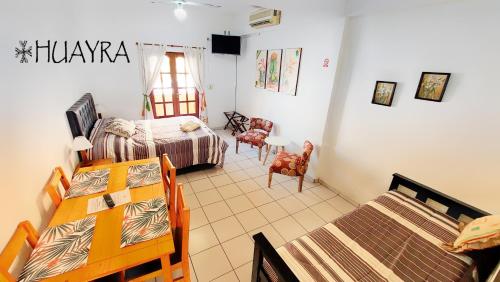 Un dormitorio con dos camas y una mesa y sillas. en Edificio Huayra, en La Rioja