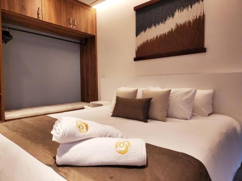 Una habitación de hotel con una cama con toallas. en Singular Dream Beach Residences, en Playa del Carmen