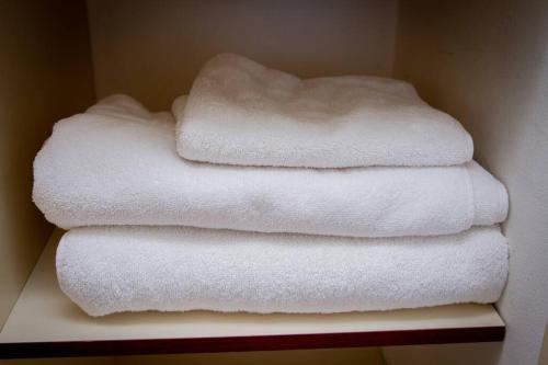 uma pilha de toalhas brancas numa prateleira em Quedate aqui Centro Concepcion I em Concepción