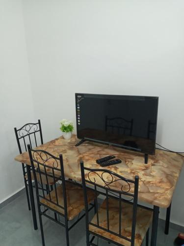 una mesa con sillas y un televisor encima. en רימון יחידות אירוח Vacation units RIMON, en Ashkelon