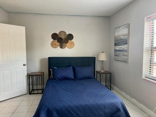 1 dormitorio con cama azul y edredón azul en Coral Gable 3BR house Parking & en Miami
