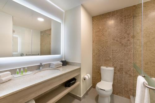 a bathroom with a sink and a toilet and a mirror at Holiday Inn - Piura, an IHG Hotel in Piura