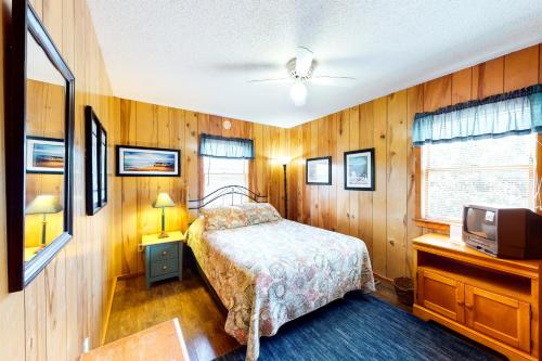 a bedroom with a bed and a tv in it at Pirate's Light #73-B in Buxton