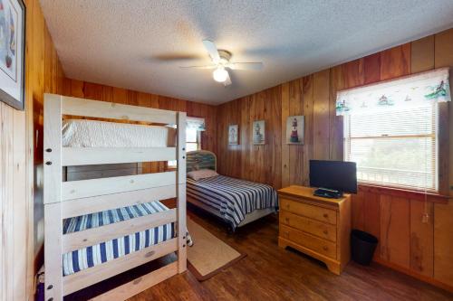 a bedroom with a bunk bed and a desk with a computer at Pirate's Light #73-B in Buxton