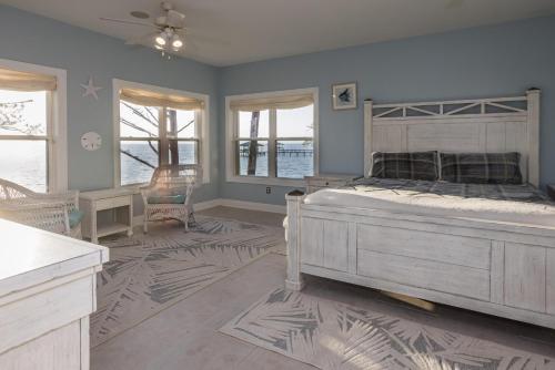 Schlafzimmer mit einem Bett, einem Tisch und Fenstern in der Unterkunft Monet On The Bay II in Magnolia Springs