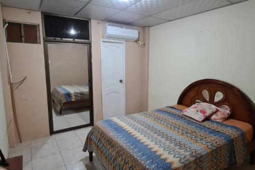 Dormitorio pequeño con cama y espejo en For travelers / Entire Home in Guayaquil, en Guayaquil