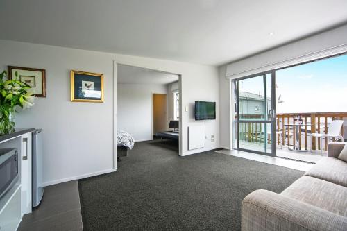 a living room with a couch and a television at Kohimarama Beach Bed & Breakfast in Auckland
