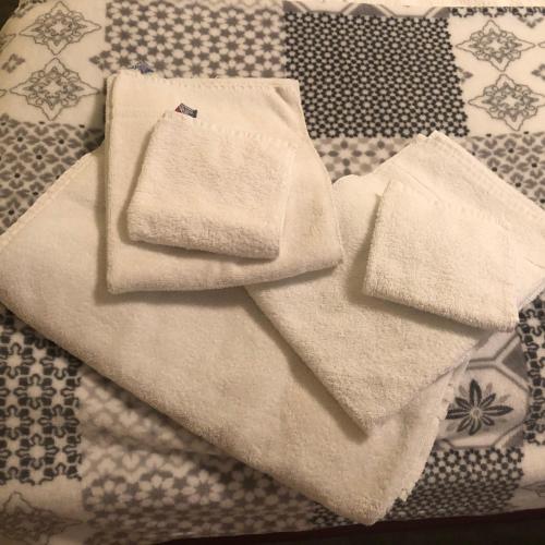 a pile of towels sitting on top of a bed at Limburger MiKa -Whg3Zimmer P&Wallbox Garten in Limburg an der Lahn