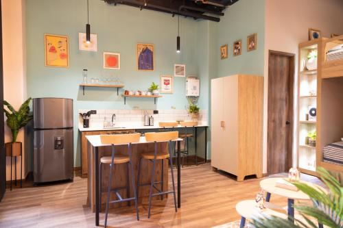 a kitchen with a counter and stools in a room at Royal Living Poblado in Medellín