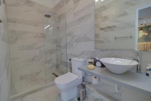 a bathroom with a toilet and a sink and a shower at AthINN Residence in Athens