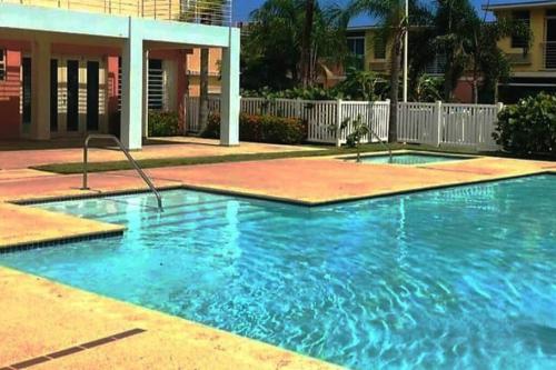 a swimming pool with blue water in front of a house at Near Islaverde Beach home Carolina Puerto Rico. in Carolina