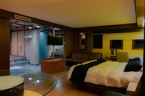 ein Schlafzimmer mit einem Bett und ein Wohnzimmer in der Unterkunft Hotel Contadero Suites y Villas in Mexiko-Stadt