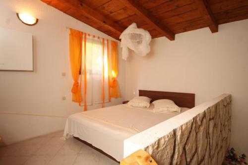 a large bed in a room with a window at Apartments with a parking space Rukavac, Vis - 2444 in Rukavac