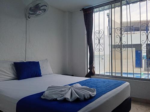 a bedroom with a bed and a window with a view at Blue Star Hotel in Melgar