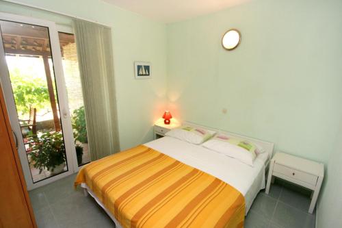 ein Schlafzimmer mit einem Bett in einem Zimmer mit einem Fenster in der Unterkunft Apartments by the sea Promajna, Makarska - 2642 in Promajna