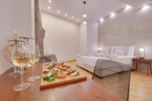 a room with a table with a plate of food and wine glasses at AthINN Residence in Athens