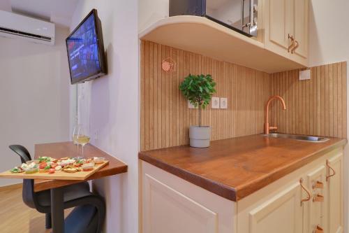 a kitchen with a sink and a table with a plate of food at AthINN Residence in Athens