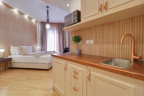 una cocina con fregadero y una cama en una habitación en AthINN Residence en Athens