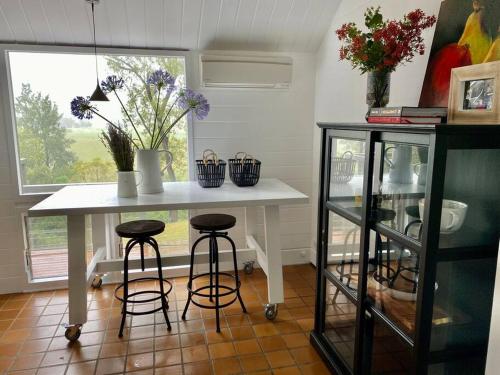 cocina con mesa, taburetes y ventana en Dungog Farmstay - Kingaley, 