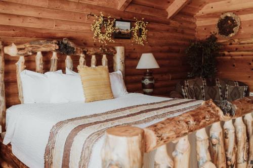 1 dormitorio con 1 cama en una cabaña de madera en Bryce Canyon Log Cabins, en Tropic