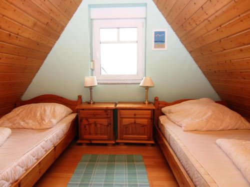 two beds in a room with a window at Doppelhaushälften in Strandnähe in Boltenhagen in Boltenhagen