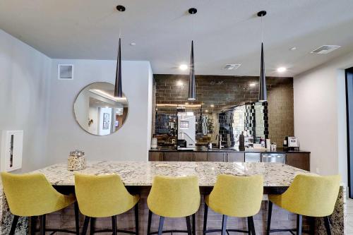 uma cozinha com uma grande mesa de mármore e cadeiras amarelas em Walk Score 81-Shopping District-King Bed-Parking - G4004 em Scottsdale