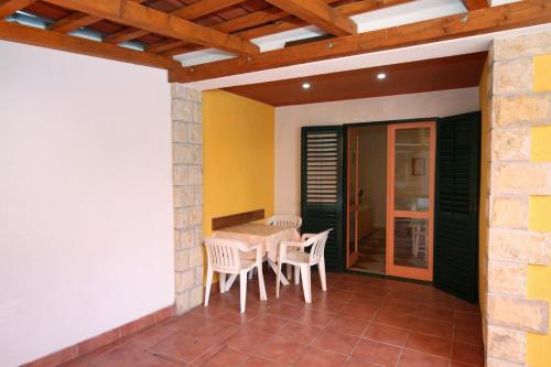 a room with a table and chairs on a patio at Apartments by the sea Promajna, Makarska - 2674 in Promajna