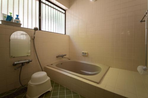a bathroom with a bath tub and a mirror at SABAE MEGANE HOUSE- Vacation STAY 5077 in Sabae
