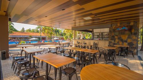 um restaurante vazio com mesas e cadeiras de madeira em Complejo Americano em Porto Iguaçu