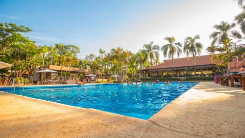 a pool at a resort with people swimming in it at Complejo Americano in Puerto Iguazú