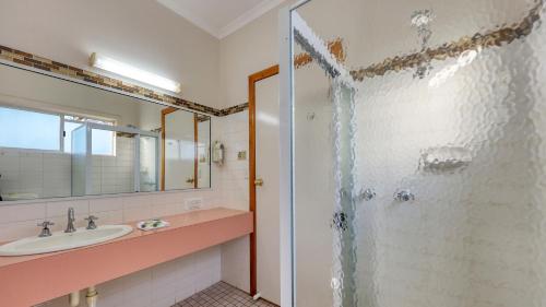 ein Bad mit einem Waschbecken und einer Dusche in der Unterkunft Chinchilla Great Western Motor Inn in Chinchilla