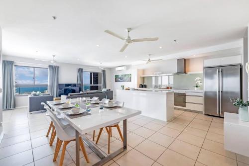 a kitchen and living room with a white table and chairs at Arafura Edge - Resort Living and Breathtaking Views in Darwin