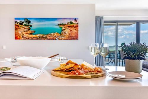 a table with a plate of food on top of it at Arafura Edge - Resort Living and Breathtaking Views in Darwin