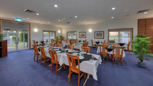 a restaurant with tables and chairs in a room at Chinchilla Great Western Motor Inn in Chinchilla