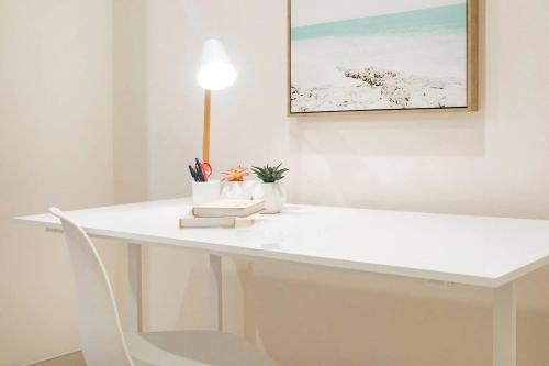 a white desk with a white chair and a painting at Luxe Bayview Oasis with Dream Waterfront Pool in Darwin
