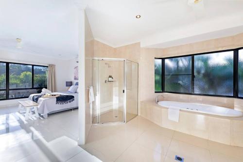 a large bathroom with a shower and a bath tub at Luxe Bayview Oasis with Dream Waterfront Pool in Stuart Park