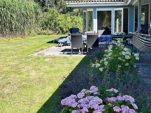 a porch with a table and some purple and white flowers at 10 person holiday home in Dannemare-By Traum in Dannemare
