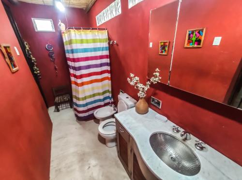 Baño rojo con lavabo y aseo en LA PACHAMAMA en San Juan