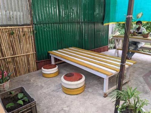 a wooden bench sitting on a patio next to a table at Mezenga Backpackers in Guwahati
