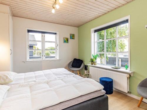a bedroom with a large bed and two windows at 8 person holiday home in Skagen-By Traum in Skagen