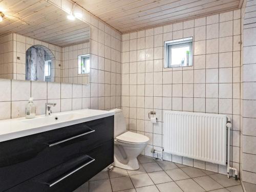 a bathroom with a sink and a toilet and a mirror at 8 person holiday home in Skagen-By Traum in Skagen