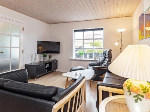 a living room with black leather furniture and a tv at 8 person holiday home in Skagen-By Traum in Skagen