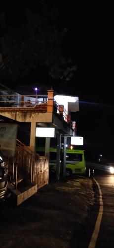a gas station at night with a green van parked in front at Bintang Bungalow Tour & Travel in Kelimutu