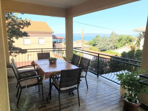 a patio with a table and chairs on a balcony at Apartments with parking space Novi Vinodolski - 2416 in Novi Vinodolski
